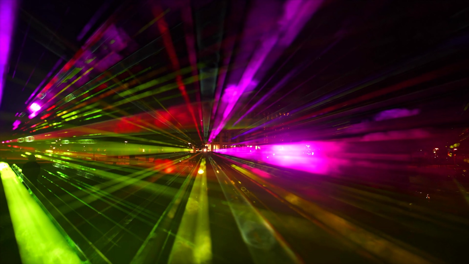 Visitors standing inside ÆTHER, a walk-in installation of green, magenta and blue light beams in fog at the Marx-Engels-Forum in Berlin