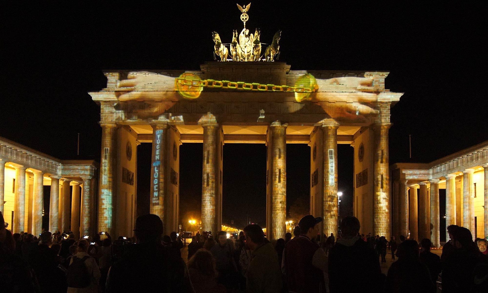 The Brandenburg Gate in Berlin under a 3D projection mapping by RE:SORB, with the crowd watching