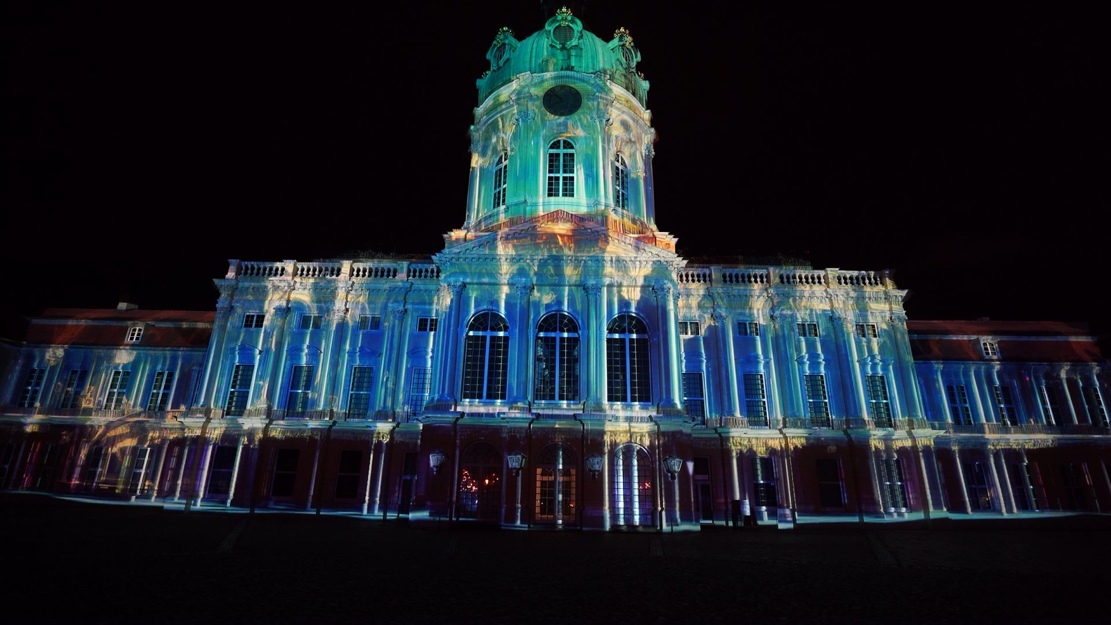 The façade of Charlottenburg Palace in Berlin covered in a red and white ornamental projection mapping during the Festival of Lights