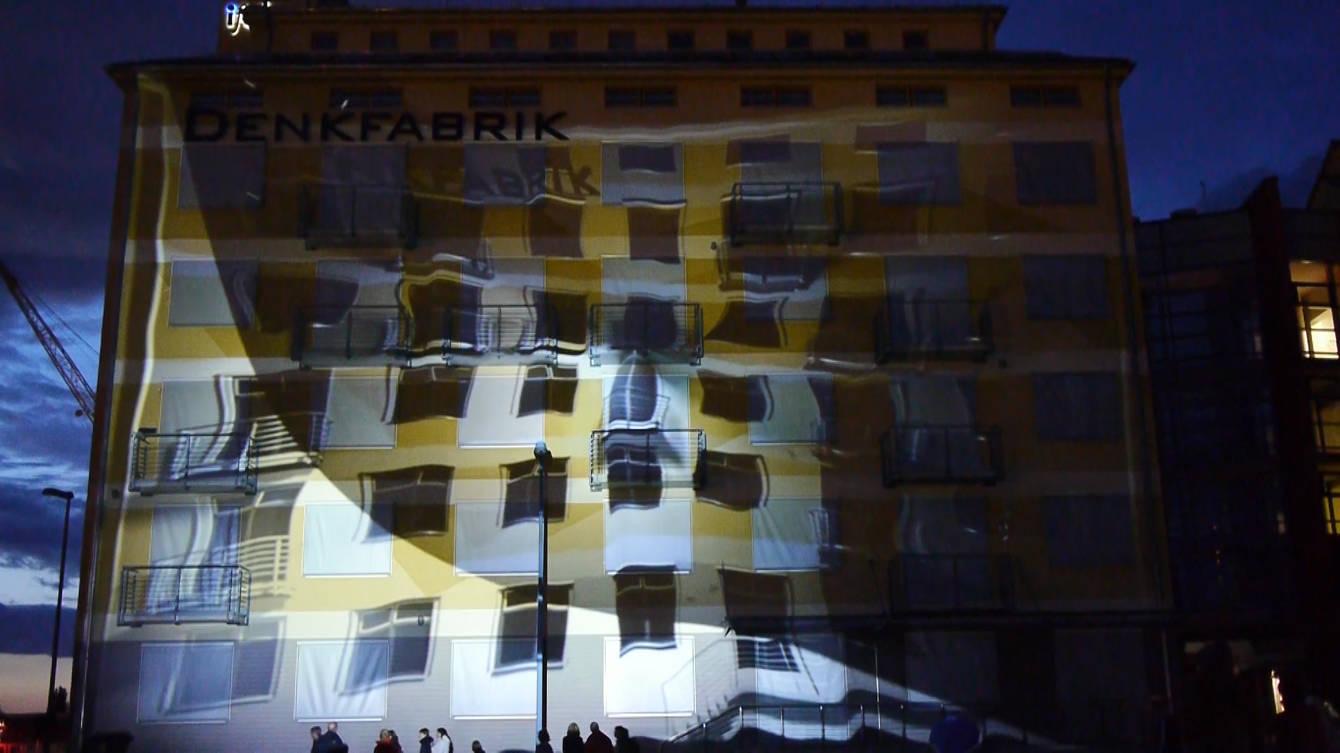 The Denkfabrik building in Magdeburg covered in a projection mapping at night