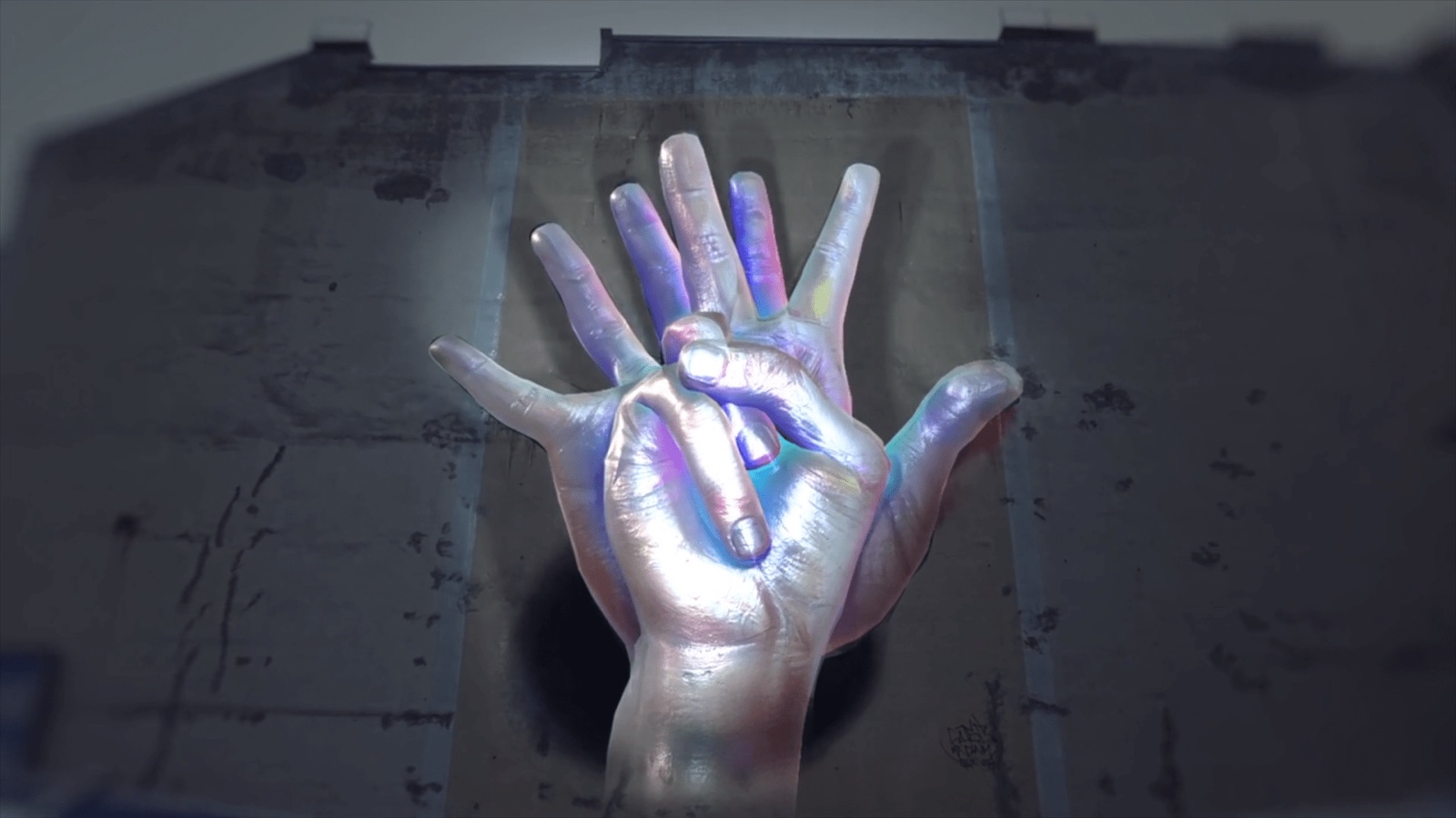 A large mural of an open hand on a building wall, animated with projection mapping
