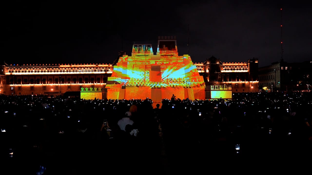 A large illuminated model of the Aztec Templo Mayor pyramid on Mexico City’s central square, watched by a crowd at night